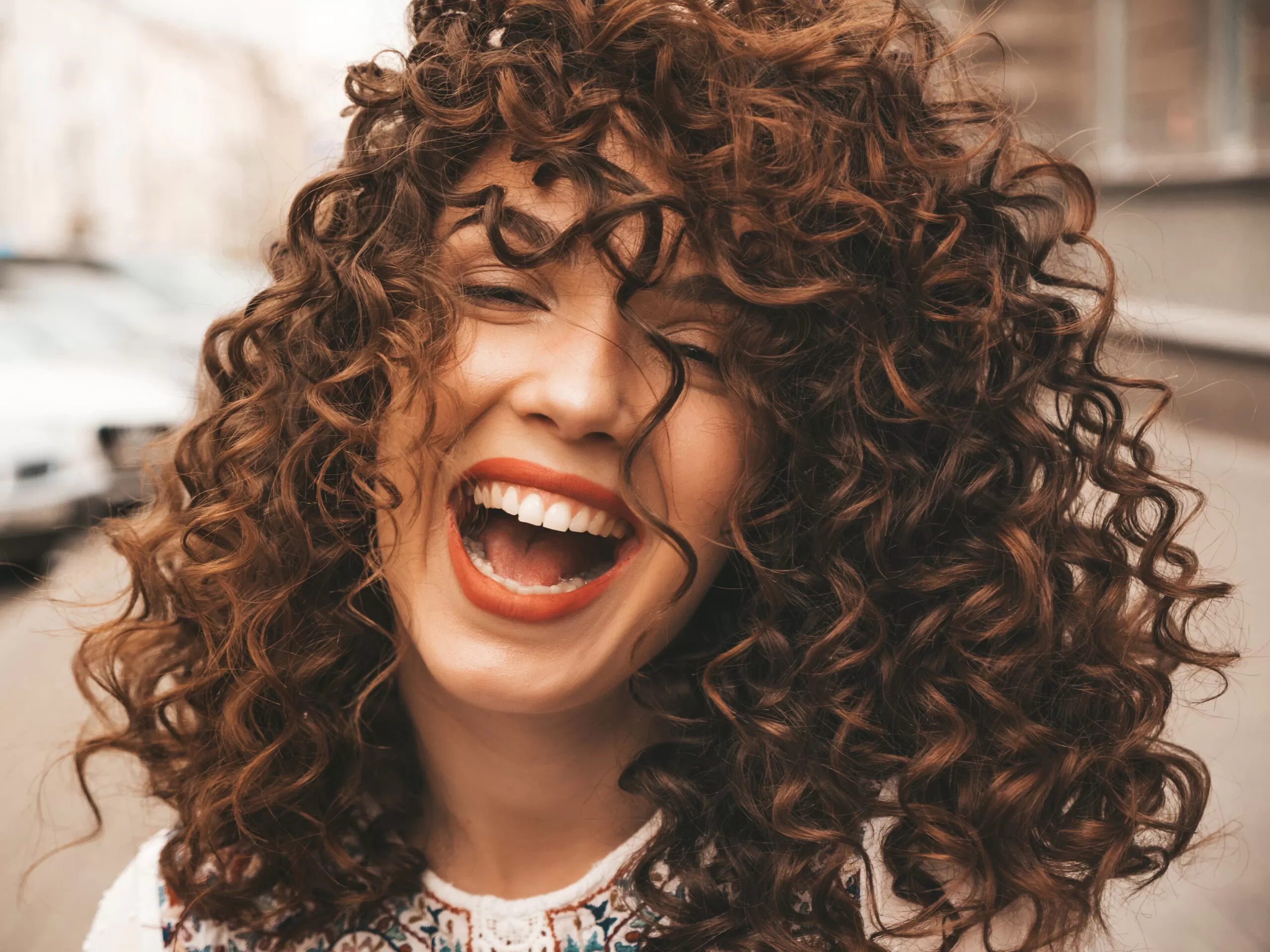 mulher sorridente com cachos perfeitos